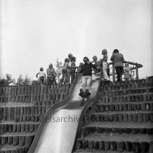 Flurbegehung der Oldesloer Stadtverordneten mit Bürgerworthalter Georg Koch und Bürgermeister Gottfried Baethge: Kinderspielplatz in der Siedlung Ehmkenberg I: Mann auf Rutsche