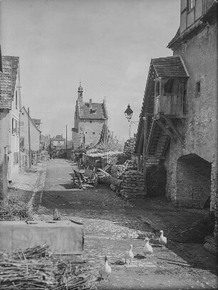 Sulzfeld am Main. Gasse an der Stadtmauer mit Maintor, Turm und Stadttorturm. Stadtseite