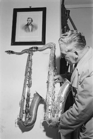 Markneukirchner Cocktail : Musikinstrumenten-Museum Markneukirchen. Mann präsentiert Tenor-Saxophon der Gebrüder Mönnig neben Ausstellungsstück Tenorsaxophon von Adolphe Sax