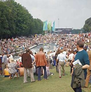 Hansjakob, Gottfried; Augsburg - Spickel, Am Eiskanal 30A; Kanuslalom Olympiastrecke, Freiflächengestaltung - Wettkampfstrecke während Olympiade, Tribünen und Brücke mit Zuschauern, Blick Richtung Norden