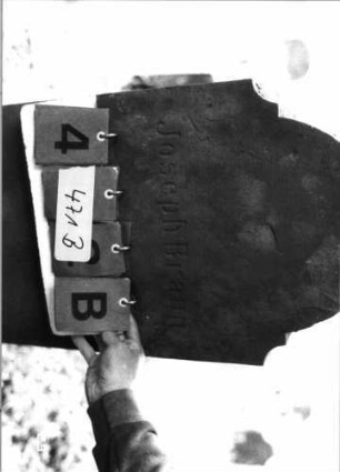 Grabstein 471 (Index: 100108029) Material: roter Sandstein Zustand: Stele abgebrochen und repariert Maße HxBxT: 122x41x22 cm Beschreibung: Stele, in zwei Knicken eingezogener Rundbogenabschluß, Schriftfeld eingetieft, getreppter Sockel Symbolik: Voluten, Palmette Besonderheit: Kindergrab: Grabstein 471B