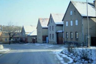 Dorfplatz, südliche Häuserzeile, Ensemble giebelständiger Häuser, geradeaus alte Gastwirtschaft