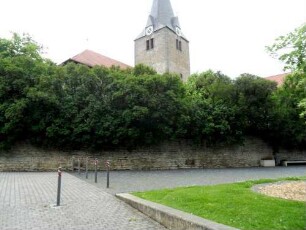 Ansicht von Südosten mit Kirche über Kirchhofmauer in Übersicht zu ebener Lage am Ortsrand