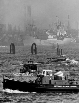 Hamburg. Emsige Betriebsamkeit im Hafen bei Herbstnebel.