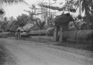 Dorfmauer : Landstraße mit Dorfmauer aus Lehm und mit Gras bedeckt und ein Dorfbewohner