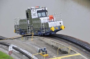 Miraflores-Kanalschleuse mit Lokomotive : Am 80 km langen Panama-Kanal vom Atlantik zum Pazifik können Besucher in der Miraflores-Schleuse die Durchfahrt großer Containerschiffe beobachten. Mit diesen Lokomotiven werden die Schiffe durch die Schleusenkammern gezogen. Aufgenommen am 15. September 2011