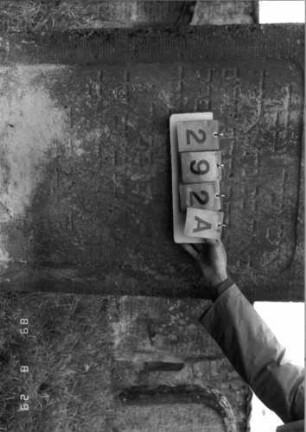 Grabstein 292 (Index: 100107691) Material: heller Sandstein Zustand: stark verwittert und versalzen, weitgehender Textverlust Maße HxBxT: 147x75x12 cm Beschreibung: Stele, Abschluß: Sonderform (rund eingezogener Kleeblattbogen), Schriftfeld rechteckig eingetieft: Grabstein 292A (Detailaufnahme 1)