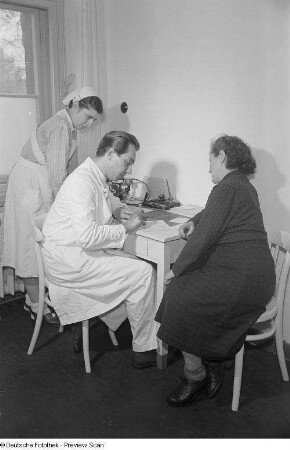 Arzt und Krankenschwester mit Patientin