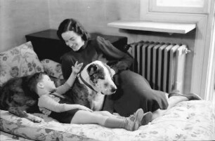 Bukarest: Haus des + Schriftleiters Wilhelm Müller, Frau Müller mit Junge und Hund auf Sofa, liegend
