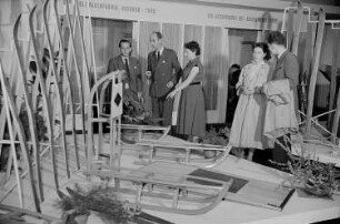 Mehrere Personen betrachten auf der Leipziger Herbstmesse 1955 Wintersportgeräte aus Holz