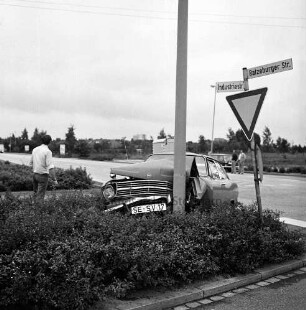 Verkehrsunfall: Kreuzung Industriestraße mit Ratzeburger Straße: Zusammenstoß von zwei Pkws: ein Unfallwagen mit eingedrückter Front an Lichtmast, auf Verkehrsinsel, links Mann: Straßenschild, Verkehrsschild: quer Ratzeburger Straße, an Straßenrand Bauwagen, parkender Pkw, zwei Personen: im Hintergrund Häuser