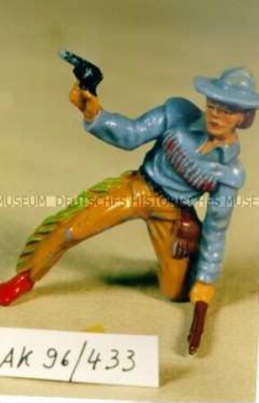 Kniender Cowboy mit Revolver