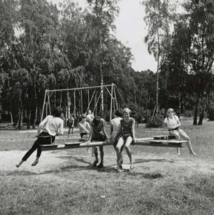 Kinder auf dem Spielplatz mit Schaukel und Karussell