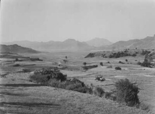 Landschaft : Blick in ein Tal, mittig ein Fahrzeug