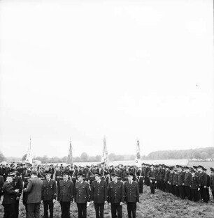 Oetjendorf: Amtfeuerwehrfest: Festwiese: Ehrung für 25-jährige Mitgliedschaft für Gerhard Finnern, Otto Buttgereit, Walter Fobian, Hans Lübke, Wilhelm Rathje, Hugo Taplick, Bernhard Winkelmann, Werner Hinsch und HermannWende durch Kreisbrandmeister Heinz Poschmann und Regierungsrat Alwes: dahinter Feuerwehrmänner: im Hintergrund Häuser und Bäume