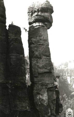 Sächsische Schweiz, Affensteine. Mittelwandspitze nordwestlich vom Kleinen Winterberg. Kletterer beim Sprung zurück zum Massiv