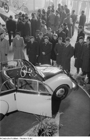 Besucher vor einem Messestand mit einem Automobil