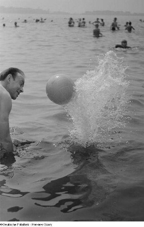 Mann im Wasser, mit einem Ball spielend