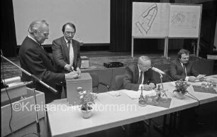 Bürgermeisterwahl: Aula der Joachim-Mähl-Realschule: Bürgervorsteher Theo Ohlen, Harald Klückmann, Fritz Lange und andere Stadtverordneten an Tischen: Wahlurne auf Tisch: rechts Rednerpult mit Mikrofon: im Hintergrund Bühne mit Aufstellern
