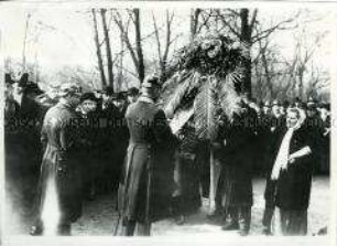 Polizisten kontrollieren die Aufschriften der Kranzschleifen vor dem Friedhof der Märzgefallenen
