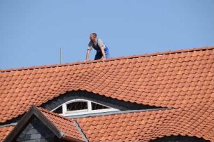 Dachreiter in Wernigerode : Aus unerklärlichem Grund steht ein Mann am Marktplatz auf dem Dachfirst eines Hauses und sieht auf die Gasse. Aufgenommen in Wernigerode im Mai 2008
