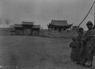 Gebäude im chinesischen Baustil : Ein Tor und ein Gebäude im chinesischen Baustil vor einer Mauer