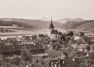 Groß Tschernosek an der Elbe (Velké Zernoseky (Böhmen)). Ortsteilansicht mit St. Nikolaus Kirche. Blick elbabwärts gegen Milleschauer (Milesovka), Kletschen (Kletecná), Kuckucksberg und Dreikreuzberg (Tříkřížový vrch oder Kalvárie) (von links nach rechts)