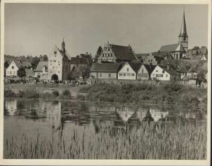 Unterfranken. Blick über den Main auf Sulzfeld mit Maintor und Renaissance-Rathaus mit reich verziertem Volutengiebel, im Hintergrund rechts die Pfarrkirche St. Sebastian