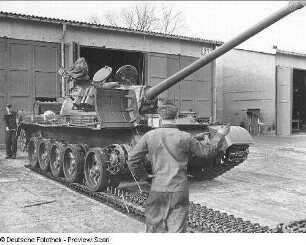 Goldberg (Kreis Lübz). Nationale Volksarmee - Landstreitkräfte. Panzerregiment 8 (PR-8). Freifläche vor Panzerhallen. Soldaten bei Instandsetzungs- bzw. Wartungsarbeiten an Gleisketten für Kampfpanzer T-54