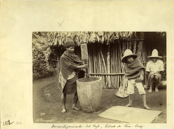 Family in front of their hut peeling and drying coffee beans.