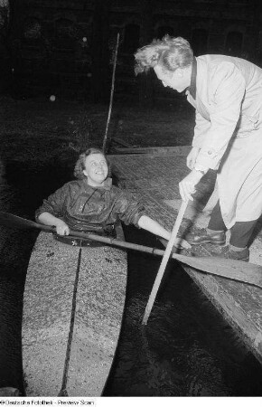 Eine Frau im Kajak legt an einem Steg an
