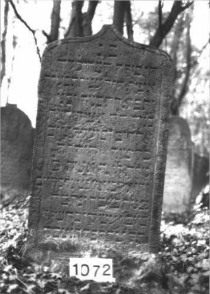 Grabstein 1072 (Index: 99899708) Material: Sandstein Zustand: angewittert Maße HxBxT: 126x62x9 cm Beschreibung: Stele mit oben abgeflachtem Kielbogenabschluss: Grabstein 1072