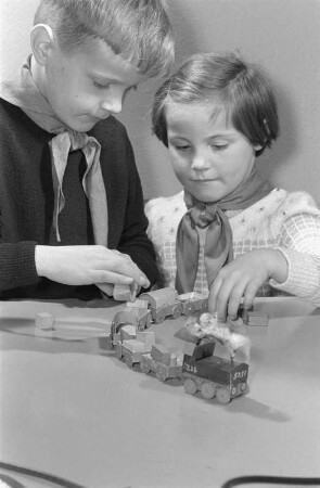 Junge Pioniere beim Basteln. Junge und Mädchen mit Spielzeugeisenbahn