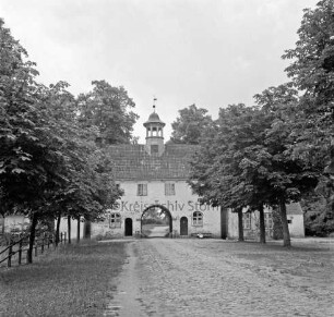 Gut Jersbek: Torhaus mit Flügelbauten: im Vordergrund Innehof mit Baumreihen, Weg und Grünanlage