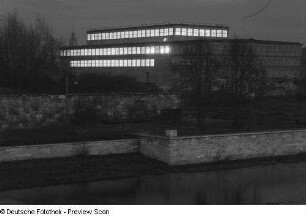 Die beleuchtete Ernst-Grube-Halle der Deutschen Hochschule für Körperkultur bei Dunkelheit