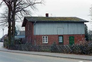 Meilsdorf: Dorfstraße 54: giebelständiges Wirtschaftsgebäude: Traufseite, Stalltür, Eingangstür, darüber Luke, Obergeschoss mit Verbretterung: an Straße zwei Bäume, Jägerzaun
