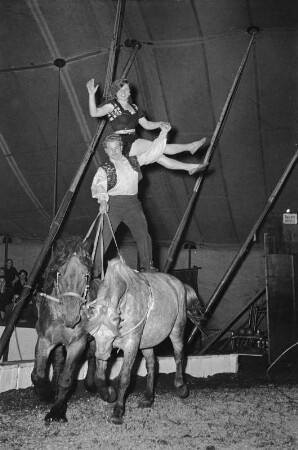 Zirkusdarbietung. Artisten auf Pferdepaar (vielleicht im Circus Aeros)