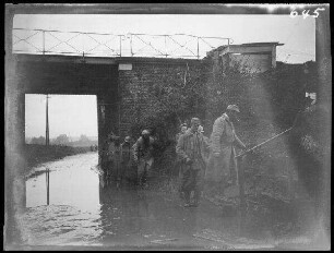 bei Neuville (=Neuville-Saint-Vaast, Dep. Pas-de-Calais, Frankreich): Soldaten (französische Kriegsgefangene?) entlang einer überfluteten Unterführung
