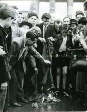 Demonstranten verbrennen am 17. Juni 1953 die rote Fahne vom Brandenburger Tor