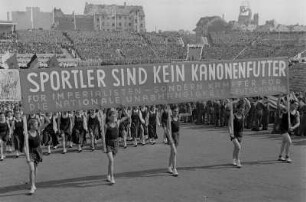 Sportlerparade im Walter-Ulbricht-Stadion : Sportlerparade im Berliner Walter-Ulbricht-Stadion (das spätere Stadion der Weltjugend). Sportler-Delegation im Paradezug mit Transparent beim Ausmarsch aus dem Stadion