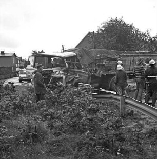 Verkehrsunfall: Dorfring: Landesstraße Richtung Stapelfeld: zwei Lkws: Lkw mit zertrümmertem Fahrerhaus in Leitplanke quer über Straße: links davor Mann: rechts Feuerwehrmänner sowie Männer: hinten Häuser