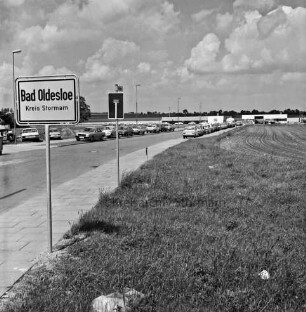 Rögen: Gewerbegebiet West: Ortseingangsschild: Einbahnstraßenschild, Straßenschild: parkende Autos, Straßenlampen: im Hintergrund Hallen von Gewerbebetrieben