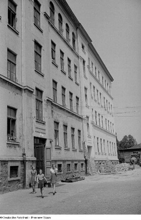 Drei Schülerinnen vor dem Schulgebäude