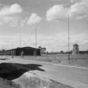 Lublin-Majdanek. Gedenkstätte ehem. Konzentrationslager Majdanek. Häftlingsbaracke gegen Wachtürme und Elektrozaun