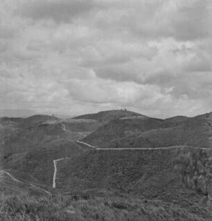 Hügellandschaft : Straße durch eine Hügellandschaft, auf einer Kuppe Lubero