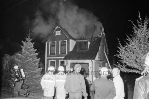 Brand: Zweifamilienhaus: vorn Feuerwehrmänner und zwei Männer: hinten Mitte Brandruine: Nacht