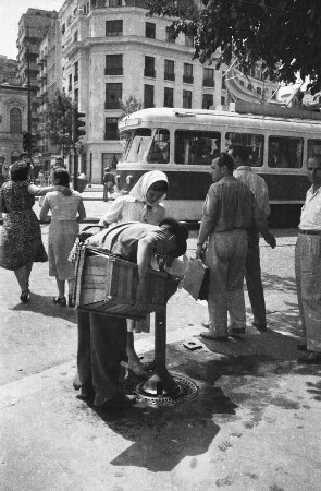 Reisefotos Rumänien. Straßenbild mit Trinkbrunnen. Im Hintergrund ein Eckhochhaus (wahrscheinlich in Bukarest)