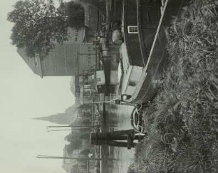 Demmin, Stadt : Demmin an der Peene. Stadt und Hafen. Im Hintergrund Turm der Stadtkirche, rechts Speicher, davor Klappbrücke. Im Vordergrund Oderkahn, Spitzheck mit Schifferbude, Krätzbeet und Wasserfaß