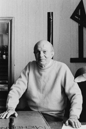 Der Maler Herbert Tucholski in seiner Wohnung mit einem Bildband über den Bildhauer Michelangelo Buonarroti
