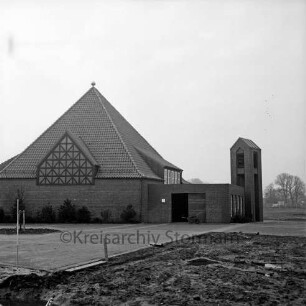 Städtischer Friedhof: Bornkampsweg: Kapelle mit frei stehendem Glockenturm, Rückseite: vor Fertigstellung: Schubkarre mit Geräten: Herrichten der Außenanlagen: frisch gepflanzter Baum